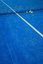 blue paddle tennis court net with five balls nearby, racket sports concept Royalty Free Stock Photo