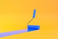 Blue Paint Roller with color trail over yellow background