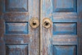 Blue painted aged worn wooden door with metal circle handle Royalty Free Stock Photo