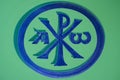 Blue painted Chi Rho symbol painted over ceramic surface