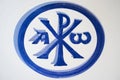 Blue painted Chi Rho symbol painted over ceramic surface