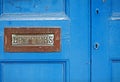 Blue painted door with brass letterbox