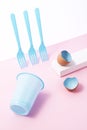 Blue painted easter egg shells with plastic forks and cup on pink background Royalty Free Stock Photo