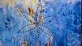 Blue painted metal door with drilled flower pattern. Rusty, stained and with fingerprints. Orange, blue, yellow. Scratched and de Royalty Free Stock Photo