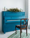 Blue painted old piano decorated with long Christmas garland Royalty Free Stock Photo