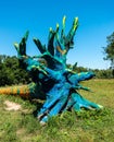 A blue painted tree trunk laying in the lawn nearby the river Isar at Munich, Bavaria, Germany