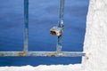 Rusty padlock on blue-painted weathered railings