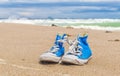 Blue pair of Worn sneakers on beach sand Royalty Free Stock Photo