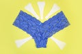 Blue panties and sanitary white napkins for woman, menstrual pads on a yellow background. Menstruation cycle. Hygiene and