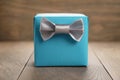 Blue paper gift box with silver ribbon bow on oak table Royalty Free Stock Photo