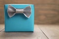 Blue paper gift box with silver ribbon bow on oak table Royalty Free Stock Photo