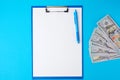 Blue paper holder with white blank sheets and a stack of paper american dollars Royalty Free Stock Photo