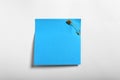 Blue paper note attached with safety pin to white background, top view Royalty Free Stock Photo