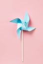 Blue paper pinweel on pink background. Energy ecological concept