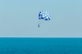 Blue parasail wing pulled by a boat in the sea water, Parasailing also known as parascending or parakiting
