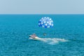 Blue parasail wing pulled by a boat in the sea water, Parasailing also known as parascending or parakiting