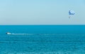 Blue parasail wing pulled by a boat in the sea water, Parasailing also known as parascending or parakiting