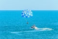 Blue parasail wing pulled by a boat in the sea water, Parasailing