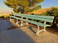 Blue Park bench in summer at sunset