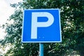 Blue parking road sign on sky and tree background Royalty Free Stock Photo