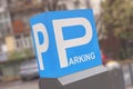 Blue parking sign letter P with parked car blur background Royalty Free Stock Photo