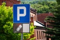 Blue Parking Sign With White P and Car Symbol in Front of Brick Building Royalty Free Stock Photo
