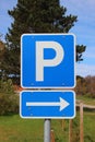 Blue parkinglot sign with right arrow and sky in background Royalty Free Stock Photo