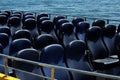 Blue passenger empty seats at a pleasure boat at the pier, a lot of blue seats, no people, against the background of the sea, conc Royalty Free Stock Photo