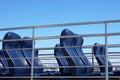 Blue passenger empty seats at a pleasure boat at the pier, a lot of blue seats, no people, against the background of the sky, conc Royalty Free Stock Photo