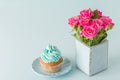 Blue pastel horizontal banner with top view of decorated with blue cream cupcake and pink roses in retro shabby chic vase. Royalty Free Stock Photo