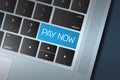 Blue Pay Now Call to Action button on a black and silver keyboard Royalty Free Stock Photo