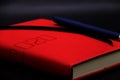 Blue pen on the red notebook 2020 close up,black and gray background Royalty Free Stock Photo