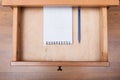 Blue pen and squared notebook in open drawer