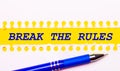 Blue pen and white torn paper stripes on a bright yellow background with the text BREAK THE RULES Royalty Free Stock Photo