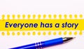 Blue pen and white torn paper stripes on a bright yellow background with the text EVERYONE HAS A STORY Royalty Free Stock Photo