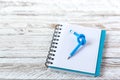 Blue Pencil with knot on writing pad on white wood background Royalty Free Stock Photo