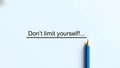 Blue pencil with sharp tip positioned on white paper below the motivational phrase \'Don\'t limit yourself Royalty Free Stock Photo