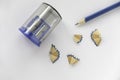 Blue pencil with pencil sharpener and its shavings on white paper background Royalty Free Stock Photo