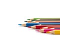 Blue pencil stands out from a number of other colored pencils lying on an isolated white background