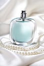 Blue perfume bottle and pearl necklace Royalty Free Stock Photo