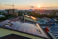 Blue photovoltaic solar panels mounted on building roof for producing clean ecological electricity at sunset. Production