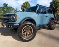 Blue pickup truck parked with gold-colored rims