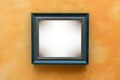 Blue picture frame on orange wall Royalty Free Stock Photo