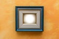 Blue picture frame on orange wall Royalty Free Stock Photo