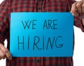 Blue piece of paper with the inscription we are hiring, concept of unemployment against the backdrop of the global crisis