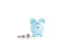 Blue piggy bank and coins isolated on white Royalty Free Stock Photo