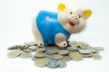 Blue piggy bank saving money and coins pile