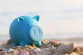 Blue piggy bank on sea beach, Saving planning for Travel budget of holiday concept