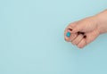Blue pill on female hand on blue background. Seasonal diseases. Right choice, medicine concept. Flat lay style with copy space,