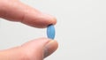 Blue pill for impotence or erectile dysfunction. Hand holding pill